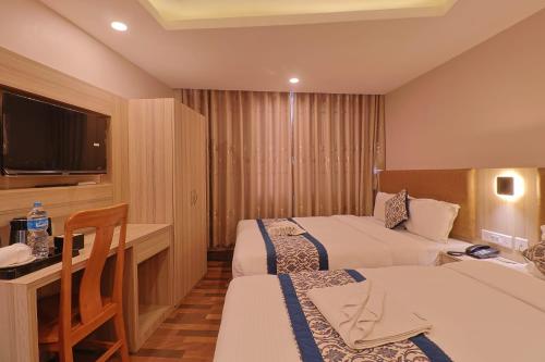a hotel room with two beds and a desk at Hotel Annapurna Palace in Kathmandu