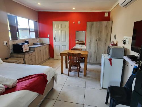 a room with a kitchen with a bed and a table at VILLA HOLIDAYS - 14A Berea Road Margate in Margate