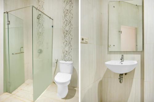 a bathroom with a toilet and a sink and a shower at Dancenter KR Hotel in Palembang