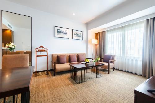 a living room with a couch and a table at Pearl River Hotel in Hai Phong
