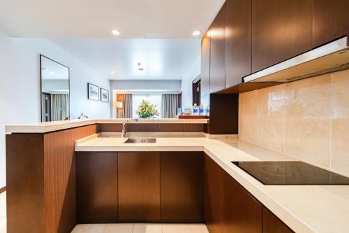 a kitchen with wooden cabinets and a sink at Pearl River Hotel in Hai Phong