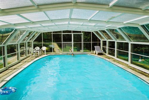 une piscine intérieure avec un plafond en verre dans l'établissement ferme de séjour verchalles, à Verchales-Soutro