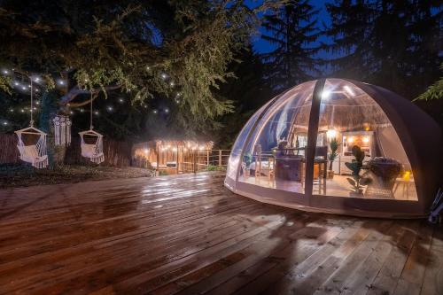a dome tent on a wooden deck at night at Sous les étoiles - Nuit insolite - Romantique & Spa in Lagnieu