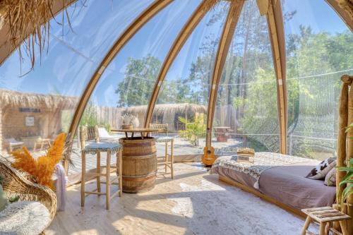 a bedroom in a dome tent with a bed and chairs at Sous les étoiles - Nuit insolite - Romantique & Spa in Lagnieu