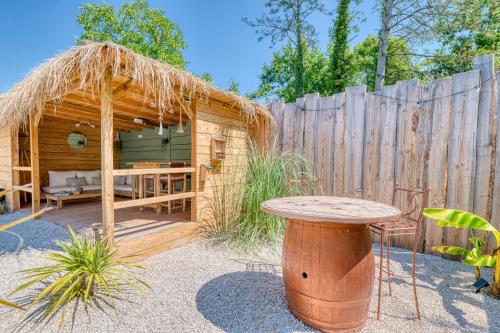 a small wooden cabin with a table and a fence at Sous les étoiles - Nuit insolite - Romantique & Spa in Lagnieu