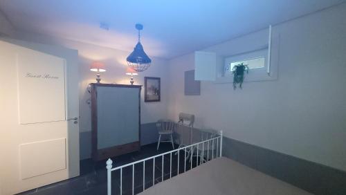 a room with a staircase with a door and a chair at B&B Van Hunebed Naar Jullie Bed in Schoonoord