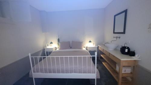 a bedroom with a white bed and a sink at B&B Van Hunebed Naar Jullie Bed in Schoonoord