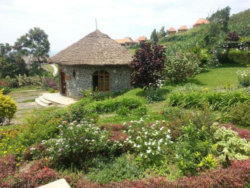 a garden with a small building in the middle at INZU Lodge in Gisenyi