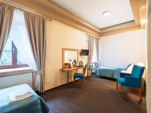 a hotel room with a bed and a desk at Zamek w Krasiczynie in Krasiczyn