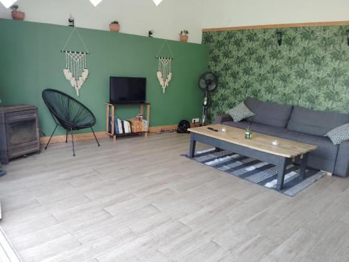 ein Wohnzimmer mit Sofa und Tisch in der Unterkunft L'Edenwine jardin clos et spa privatif in Doulezon