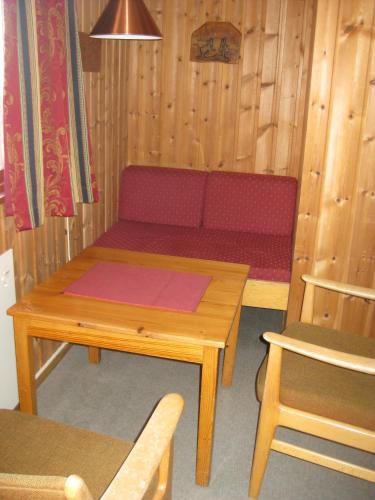 a wooden room with a bench and a table at Putten Seter in Høvringen