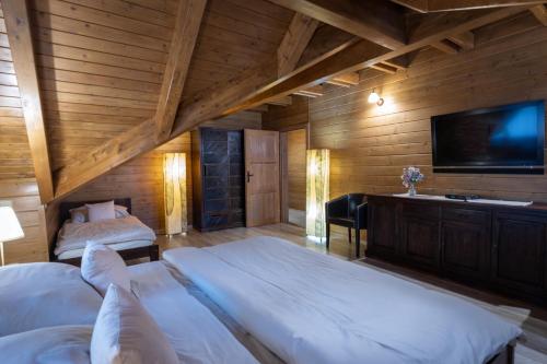 a bedroom with two beds and a flat screen tv at Chata Sidorka in Oravský Podzámok