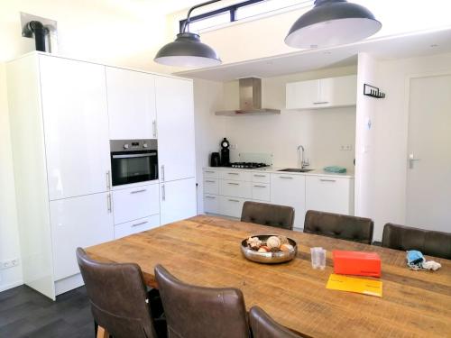 a kitchen with a dining room table and chairs at Holiday home - area AMSTERDAM - 6 people in Halfweg