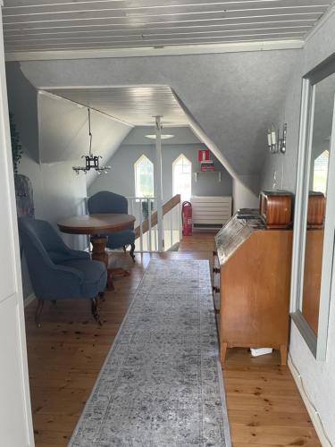 a living room with a table and blue chairs at Huset på hörnet in Hammenhög