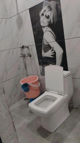 a bathroom with a toilet and a picture of a girl at Hotel Anant in Zirakpur