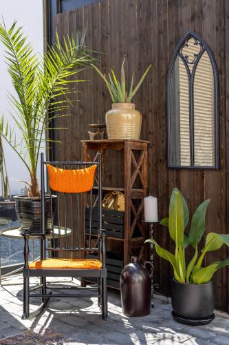 a patio with a chair and plants and a fence at White Brig Guesthouse in Hudiksvall