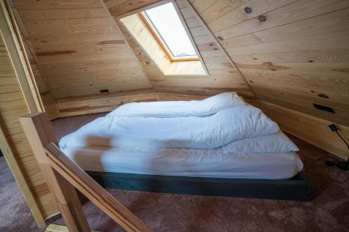 a small bed in a wooden room with a window at Complex A Toplita in Topliţa