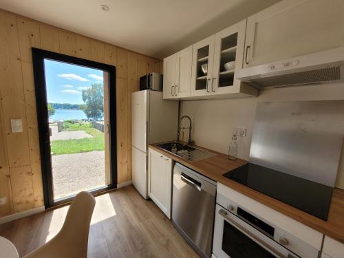 eine Küche mit einem großen Fenster mit Aussicht in der Unterkunft Maison bord du Lac des Settons in Montsauche-les-Settons