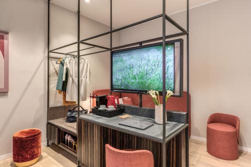 a dressing room with red chairs and a tv at Parioli Cube Hotel in Rome