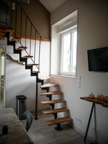 una escalera de caracol en una habitación con ventana en Le Four à Chanvre, en Saint-Genest-dʼAmbière