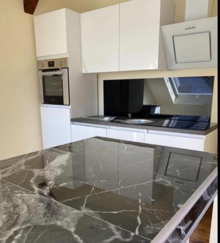 a kitchen with white cabinets and a marble counter top at Apartament an der Landgestüt in Warendorf