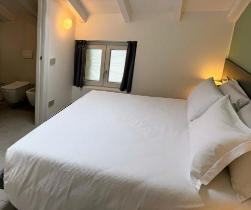 a bedroom with a large white bed with a window at Urban Living in Como