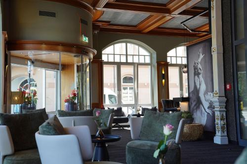 a lobby with couches and tables and windows at Hotel Porta Nigra VICTUS in Trier