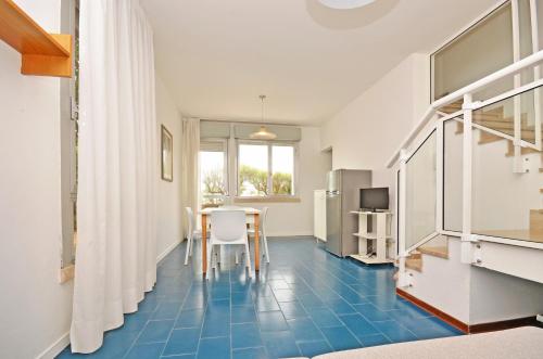 a room with a table and a blue tile floor at Residence Garuda in Cavallino-Treporti