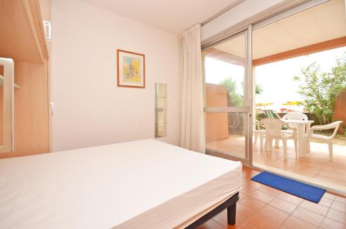 a bedroom with a bed and a balcony with a table at Residence Garuda in Cavallino-Treporti