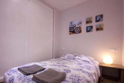 マラガにあるLivemalaga Merced Apartamentoのベッドルーム1室(ベッド1台、ランプ付きテーブル付)