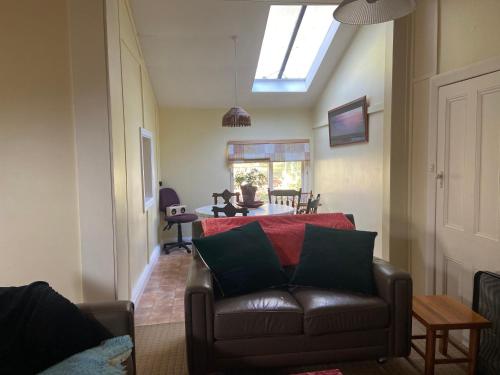 a living room with a couch and a table at Olinda Country Cottages in Olinda