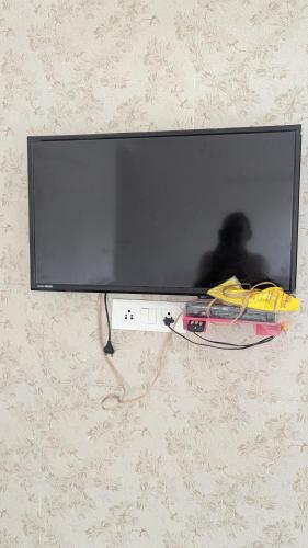 a flat screen tv hanging on a wall at Mayur Home Stay, Morni Hills in Morni