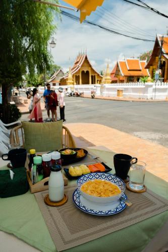 un tavolo con una ciotola di cibo e un piatto di cibo di Barn Laos Luangprabang Heritage a Luang Prabang