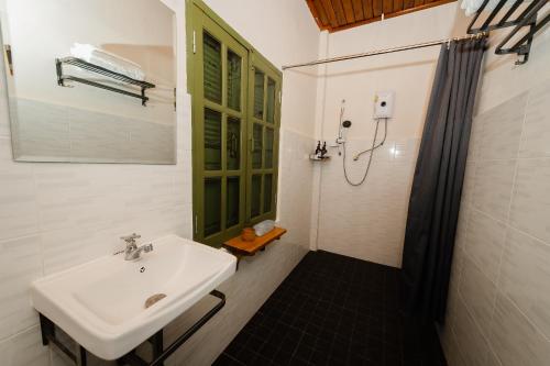 a bathroom with a sink and a shower at Barn Laos Luangprabang Heritage in Luang Prabang