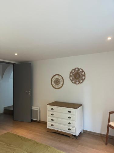 a room with a dresser and a clock on the wall at Maison d'hôtes Il était une fois in Pont-lʼÉvêque