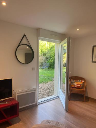 a living room with a mirror and a sliding glass door at Maison d'hôtes Il était une fois in Pont-lʼÉvêque