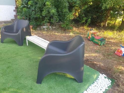 two plastic chairs and a bench in a yard at Stella di Mare in Scarlino