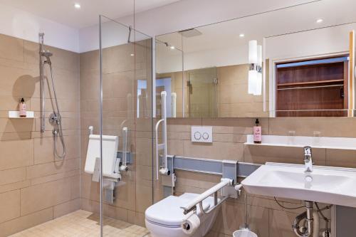 a bathroom with a toilet and a sink and a shower at Hotel Alma Am Anger in Erfurt