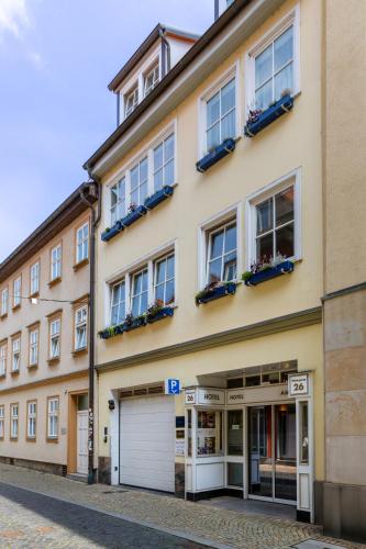 an apartment building with two garages on a street at Hotel Alma Am Anger in Erfurt