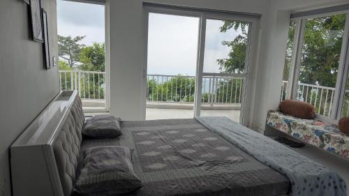 a bedroom with a bed and two large windows at Mayur Home Stay, Morni Hills in Morni