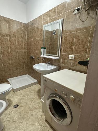 a bathroom with a washing machine and a sink at Balkan Apartaments in Shëngjin