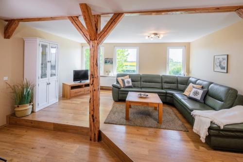 a living room with a green couch and a table at Hinrich`s Ostsee Bauernhof in Gremersdorf