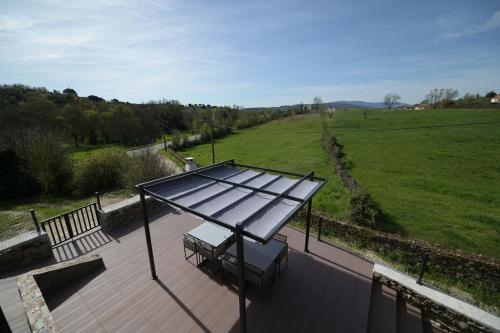 a solarium on a deck with a bench and a field at Casas do Azibeiro in Veigas