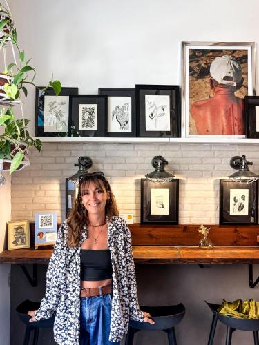 a woman standing in front of a table with pictures at 248 Boutique Studios, Sliema in Sliema