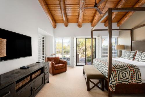 Un dormitorio con una cama y un televisor de pantalla plana. en Exclusive Boulders Retreat near Downtown Cave Creek hiking scenic views., en Cave Creek