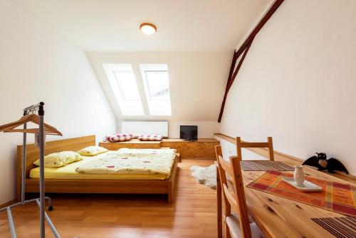 a bedroom with a bed and a table in a room at Penzion U Zámeckého parku in Žihobce