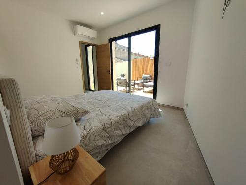 une chambre avec un lit et une lampe sur une table dans l'établissement Superbe Maison neuve Piscine Clim parking Recharge voiture électrique, à Bouillargues