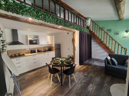 un salon avec une table et une cuisine dans l'établissement Appartement Jungle climatisé Centre Ville, à Nîmes