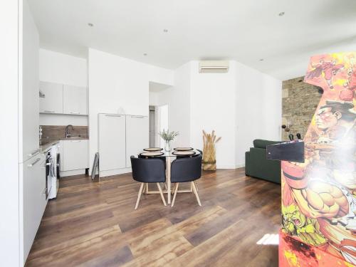 une cuisine et un salon avec une table et des chaises dans l'établissement L'ARCADIA 4 lits Climatisé Jeu d'Arcade centre historique Nîmes, à Nîmes