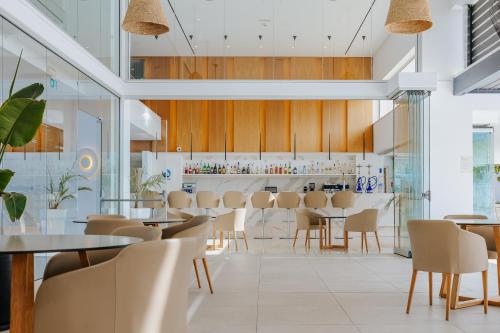 a restaurant with tables and chairs and a bar at Seasons Hotel (Adults Only) in Ayia Napa